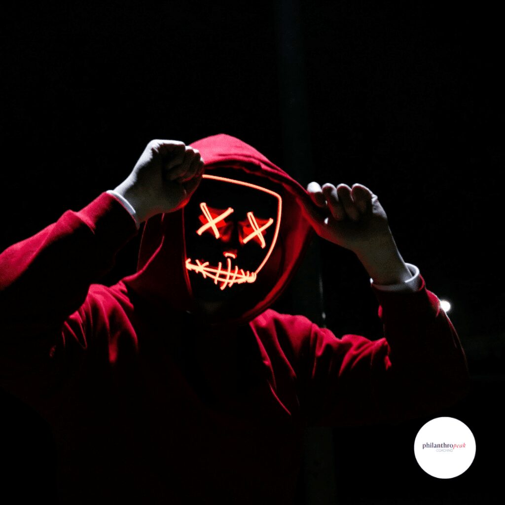 Person wearing glowing mask in dark setting.