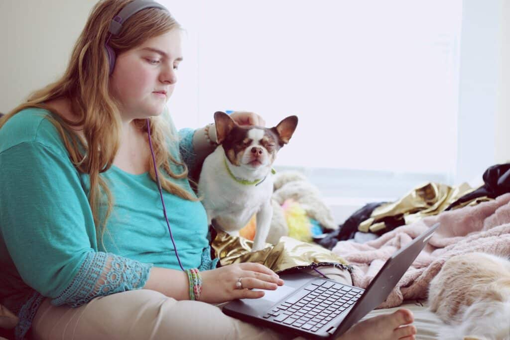 girl in blue jacket holding white and brown short coated puppy. ADHD vs Autism