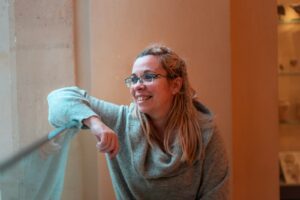 smiling woman leaning on glass board in room - ADHD In Women