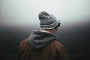 man wearing knit cap on grey background - ADHD meltdown vs autism meltdown