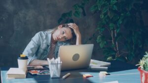 Photo by Vitaly Gariev - Philanthropeak Coaching - Philanthropeak Coaching A woman appears stressed while working on laptop. overcoming adhd in business